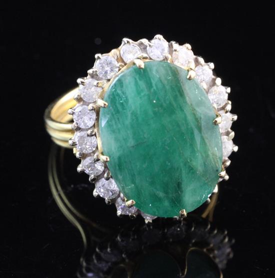 A gold, emerald and diamond oval cluster ring, size M.